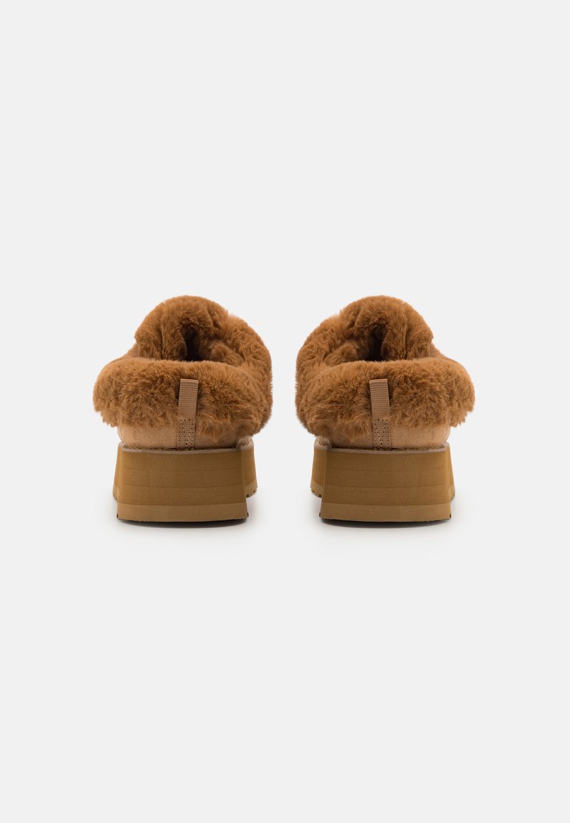 Pantofole platform in marrone con colletto di pelliccia morbida, interni soffici e una solida base beige. Il retro presenta un piccolo anello di stoffa per facilitarne l'indossamento.