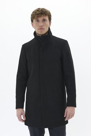 Abrigo negro hecho de un tejido estructurado, con un alto cuello, cierre de botones en la parte delantera y dos bolsillos laterales. Diseño simple y estilizado.