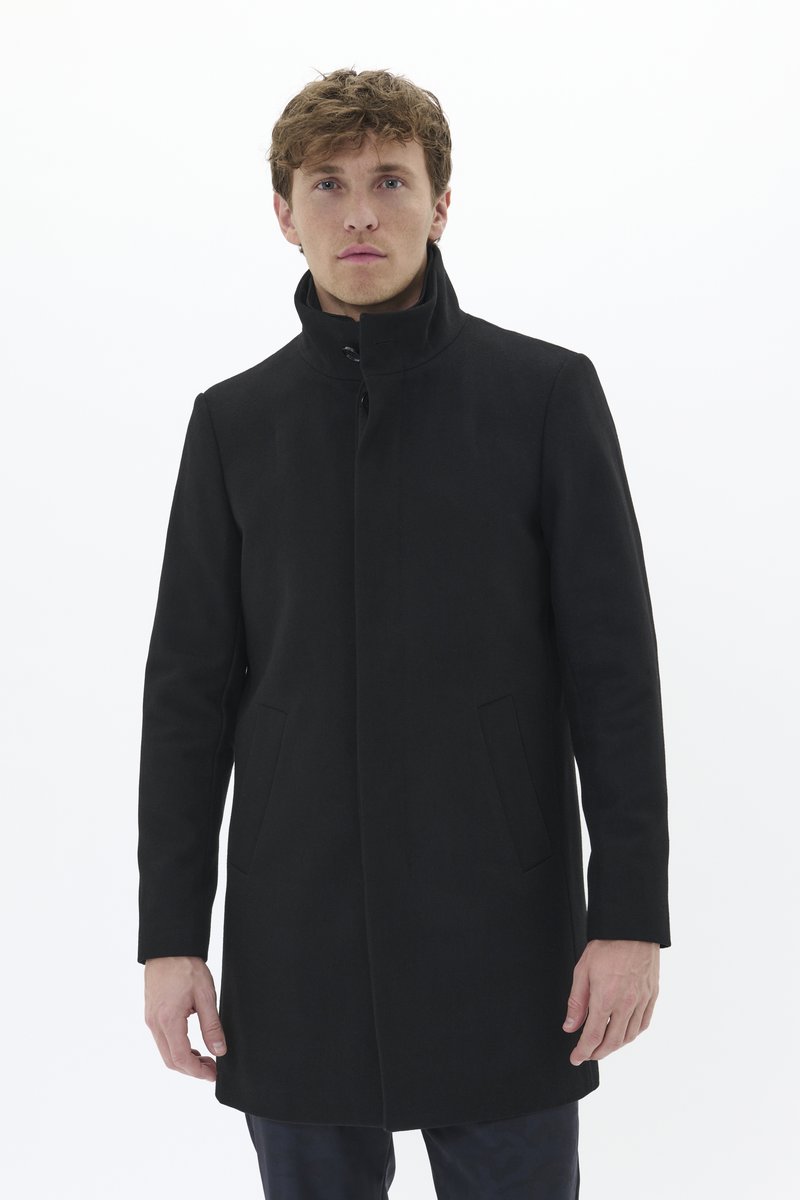 Manteau noir en tissu structuré, doté d'un col haut, d'une fermeture à boutons à l'avant et de deux poches latérales. Design simple et épuré.