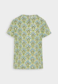 Blouse à manches courtes avec un motif floral présentant des teintes de bleu, vert et or sur un fond vert clair ; détail de dos en forme de clé.