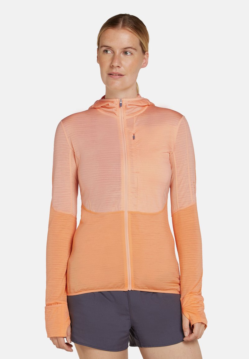Chaqueta ligera con capucha en tonos degradados de durazno y coral. Presenta un cierre completo, mangas largas y una tela texturizada con sutiles líneas de acanalado.