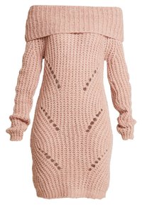 Robe-pull en maille de couleur rose pâle avec un design à épaules dénudées, texture côtelée, manches longues et détails découpés le long du corps.