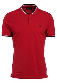 Röd polo skjorta med en tvåknappsknäppning, svart och vit randig krage och ärmslut, samt en liten broderad logotyp på bröstet.