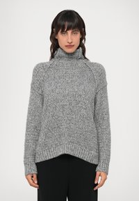 Suéter de punto gris, con un alto cuello de tortuga, puños y dobladillo acanalados, con un patrón texturizado en toda la prenda y una silueta oversized.