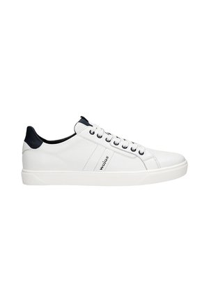 Λευκό δερμάτινο sneaker με χαμηλό κόψιμο, μαύρη ταμπέλα στη φτέρνα, λευκά κορδόνια και λογότυπο "wojas" στο πλάι, σε απλό λευκό φόντο.