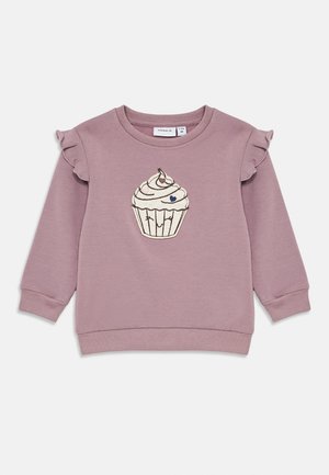 Detská fialová mikina s volánmi na ramenách a grafikou usmievajúceho sa cupcakes s čerešňou na vrchu v strede.