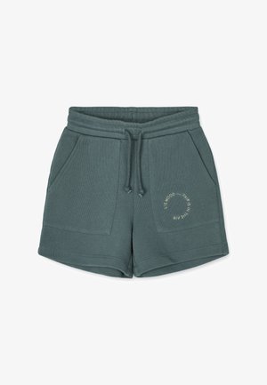 Short vert à cordon avec deux grandes poches à l'avant et un imprimé de texte circulaire sur la poche droite.