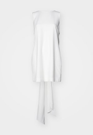 Λευκή αμάνικη μπλούζα από απαλό ύφασμα, με ίσια γραμμή και μακρύ δέσιμο στο πίσω μέρος. Χωρίς επιπρόσθετα σχέδια ή λεπτομέρειες.