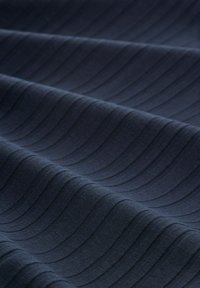 Tejido de un oscuro tono marino con un patrón de olas texturizado. Textura suave y lisa con líneas horizontales que crean profundidad y dimensión.