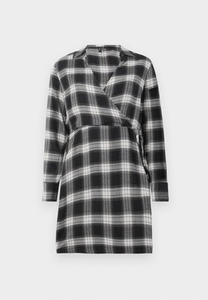 Rochie în carouri alb-negru, dintr-un material moale, cu mâneci lungi, decolteu în V și o curea la talie. Are un model cu carouri pe toată suprafața.