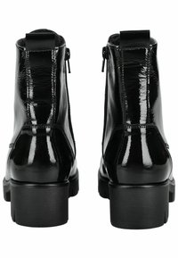 Bottines en cuir verni noir avec une finition brillante, des zips latéraux et une semelle épaisse. Présentent une boucle à l'arrière pour un enfilage facile.