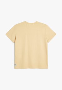 Koszulka z krótkim rękawem, prążkowana, z miękkiego żółtego materiału. Posiada okrągły dekolt i małą metkę na dole. Prosty i casualowy design.