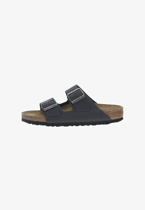 Svart tvåremmad sandal som har justerbara spännen, en korkfotbädd och en gummisula. Det övre laget har en slät yta.