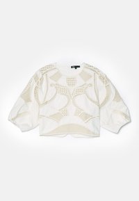 Haut court blanc présentant des motifs texturés complexes, y compris des mailles et des motifs géométriques, avec des manches bouffantes et un ourlet arrondi.