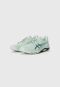 Light green athletic shoes with a textured mesh upper, laces, and a dark green stripe pattern; featuring a cushioned sole and curved design.