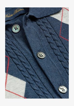 Marineblauer Strickcardigan mit Zopfmuster, silbernen Vierlochknöpfen und weißen sowie roten Argyle-Akzenten an den Seiten, mit dem Label Brooks Brothers.