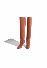 Čizmice do koljena, s uskim vrhom, od rustikalnog sueda s glatkom teksturom i tankim štiklama, s elegantnim dizajnom i minimalnim detaljima.