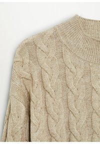 Pull beige en maille torsadée épaisse avec motifs tordus, col rond côtelé, vu du haut du torse et de l'épaule.