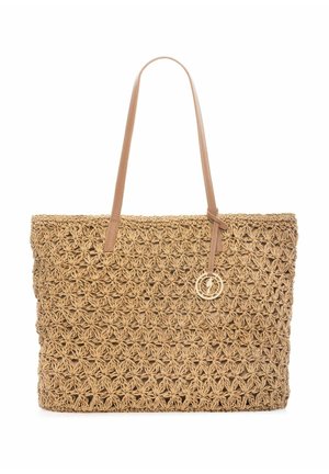 Spleciona słomiana torba typu tote z wzorem przypominającym kwiat, długie jasnobrązowe skórzane uchwyty oraz okrągły ozdobny breloczek wiszący na jednym uchwycie.