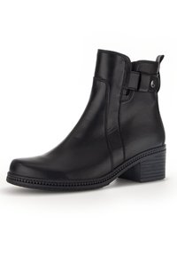 Schwarze Leder-Stiefelette mit leicht spitz zulaufender Zehenpartie, Mittelabsatz, seitlicher Schnallenakzent und strukturiertem Schaft. Insgesamt glatte Oberfläche.