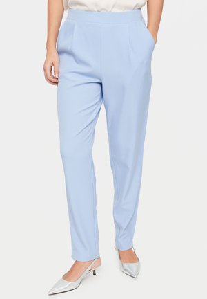 Lyseblå skræddersyede bukser i et glat stof, med frontfolder og sidelommer, parret med sølvfarvede slingback hæle.