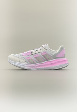Zapatilla deportiva blanca y rosa claro con parte superior de malla, suela acolchada y tres franjas rosas en el lateral, mostrada en vista de perfil.