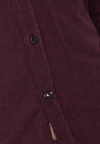 Bordeaux skjorte med knapper, lavet af et struktureret stof, med sorte knapper og et diskret sidemærke, designet til en tætsiddende pasform.