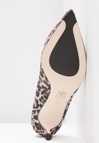 Chaussure à talon haut à bout pointu imprimé léopard vue de la semelle, avec patin antidérapant noir et estampille en cuir, taille 37.
