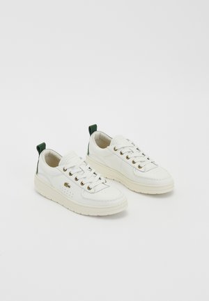Baskets en cuir blanc avec des accents verts, design à lacets, œillets dorés et panneaux texturés. Semelle en caoutchouc épaisse couleur crème.