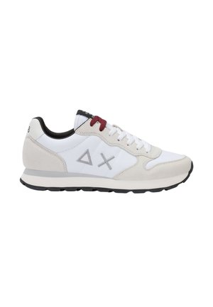 Sneaker bianca e beige con suola nera, lacci rossi e bianchi, fodera interna nera e triangoli e forme a X grigie ricamate sul lato.