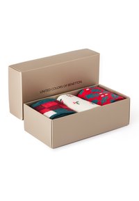 Zestaw trzech skarpetek w pudełku. Zawiera skarpetki w czerwono-kariastym wzorze, białe z kwiatowym nadrukiem oraz jaskrawoczerwone z wzorem ostrokrzewu. Kremowe pudełko.