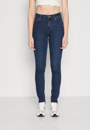 Skinny jeans in dark blue denim, featuring a classic five-pocket design, subtle stitching details, and a mid-rise waist.