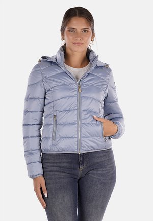 Giacca imbottita azzurra chiara con chiusura a zip, due tasche laterali e cappuccio. Presenta linee orizzontali cucite e dettagli metallici.