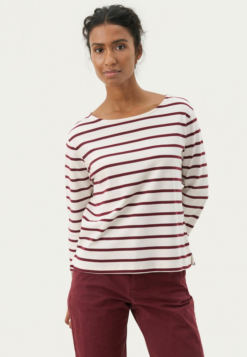 Maglietta a maniche lunghe a righe in crema e bordeaux, con scollo a barca e vestibilità rilassata. Tessuto morbido con righe orizzontali.