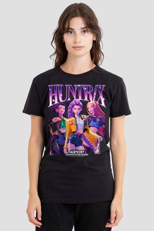 Junge Frau trägt ein schwarzes T-Shirt mit drei animierten weiblichen Charakteren unter dem fettgedruckten "HUNTRX"-Text und dem Logo "K-Pop Demon Hunters".