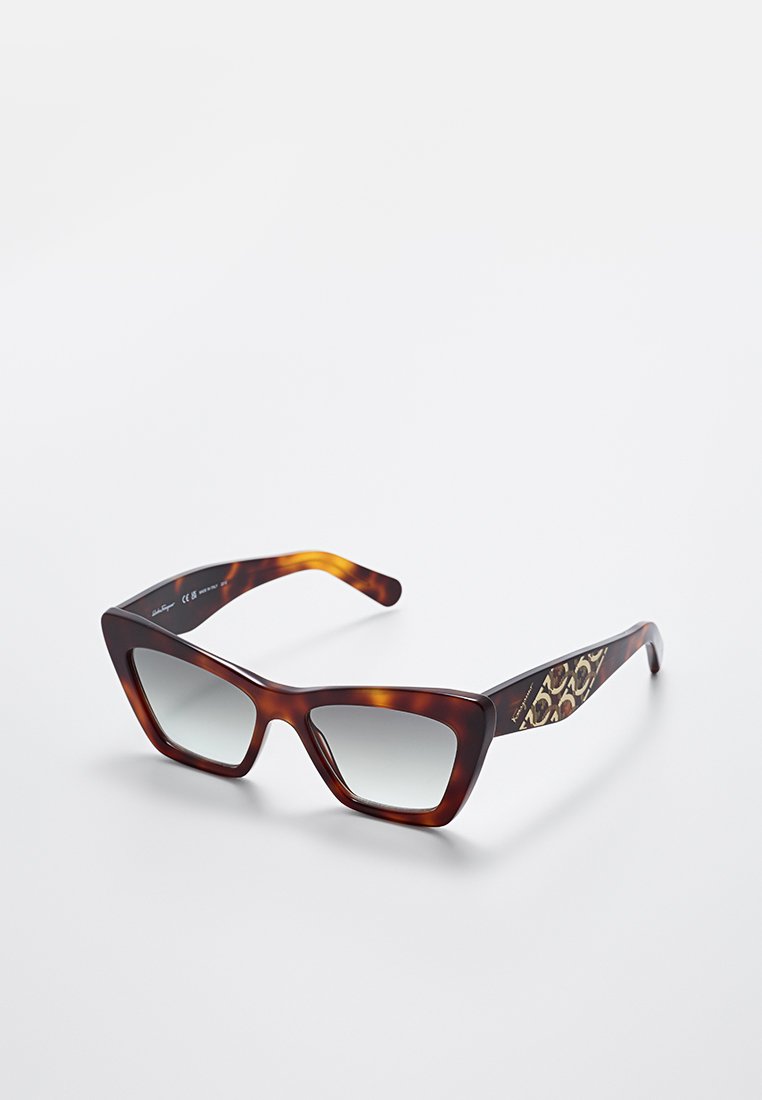 Gafas de sol de carey con montura angular, lentes con degradado gris y laterales con un diseño estampado de leopardo.