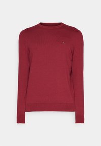 Maglione rosso lavorato a maglia con scollo rotondo e maniche lunghe. Presenta un piccolo logo in risalto sul lato sinistro del petto e polsini e orlo a coste.