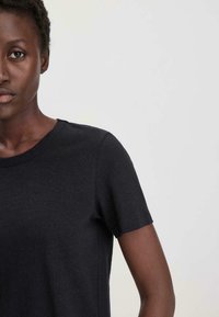 Zwarte katoenen t-shirt met korte mouwen en ronde halsline, met een gladde textuur en een standaard pasvorm ontwerp.