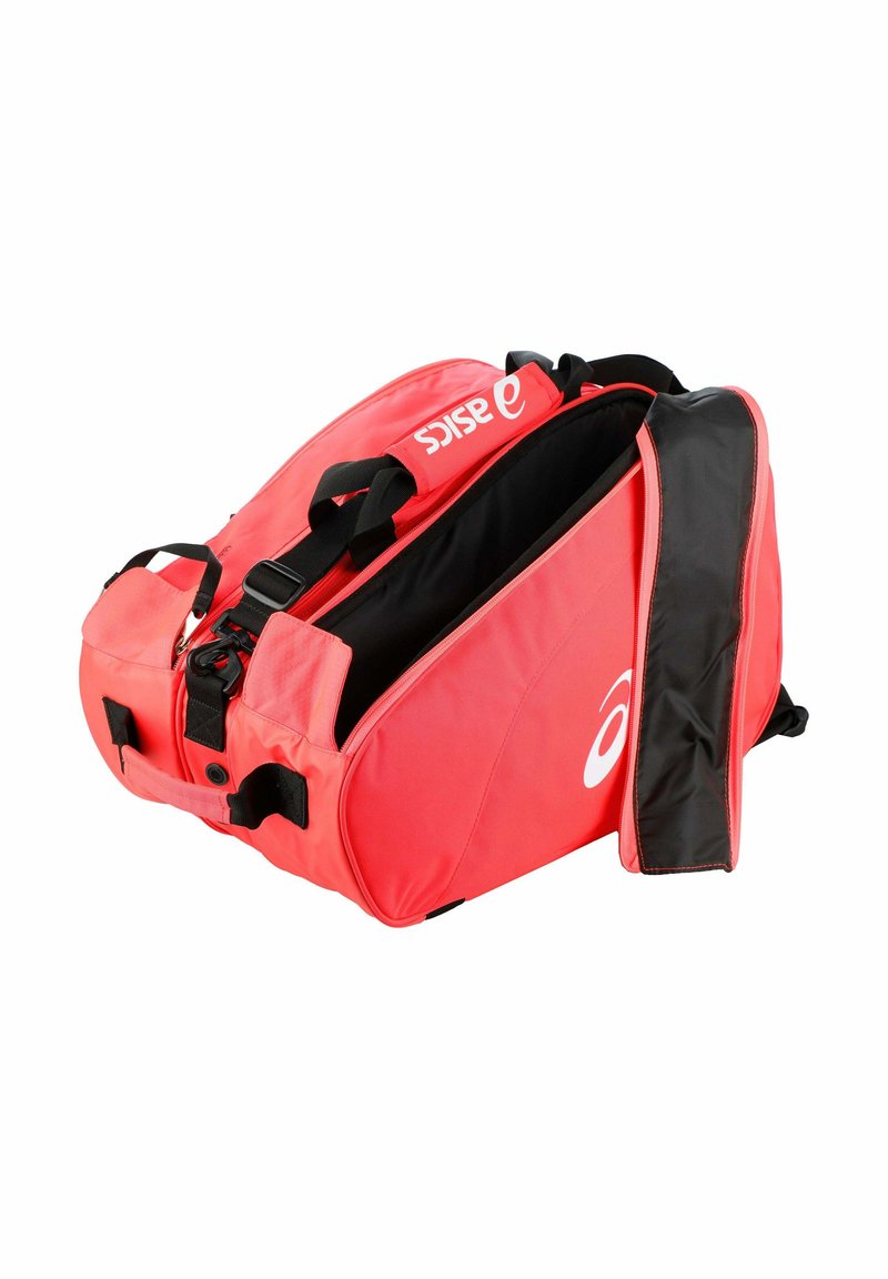 Sac de sport ASICS rouge et noir avec logo, fermeture éclair ouverte sur le dessus et bandoulière réglable sur fond blanc.