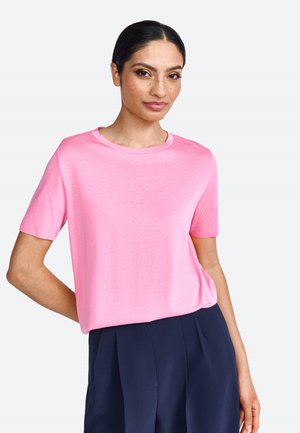 Pull en rose à manches courtes avec un col rond, fabriqué en matériau léger. Le tissu est lisse avec une coupe légèrement ample.