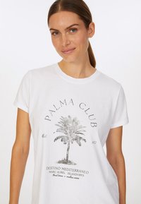 Weißes Baumwoll-T-Shirt mit einem schwarzen Grafikmotiv einer Palme und dem Text: "PALMA CLUB," mit umgeschlagenen kurzen Ärmeln und einer lockeren Passform.