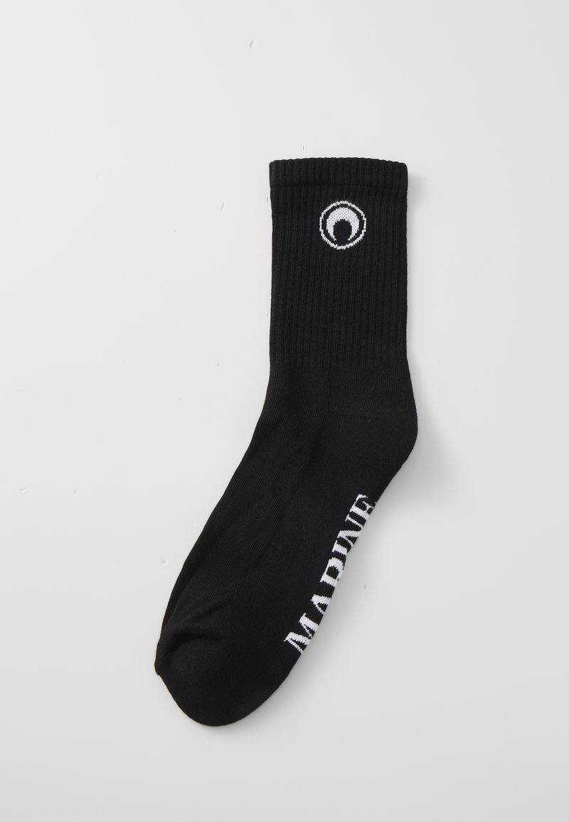Chaussette en coton noire avec texture côtelée, présentant un logo circulaire blanc au niveau de la cheville et le mot "MARINE" en blanc sur le côté.