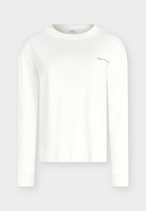 Λευκό μακρυμάνικο μπλουζάκι με στρογγυλή λαιμόκοψη και μικρό μαύρο κείμενο "keep on moving" στο πάνω αριστερό μέρος του στήθους, εμφανιζόμενο σε απλό φόντο.