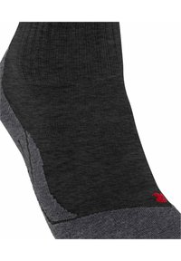Calcetín de crew en negro y gris con textura acanalada y talón reforzado. Presenta un acento de logo rojo cerca del tobillo. Material suave y elástico.