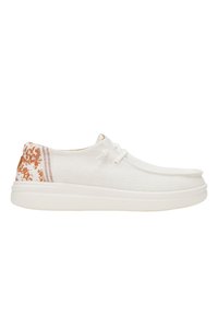 Baskets en toile blanches avec une tige texturée, présentant un accent de talon à motifs bruns et une semelle en caoutchouc blanche, conçues pour un usage décontracté.