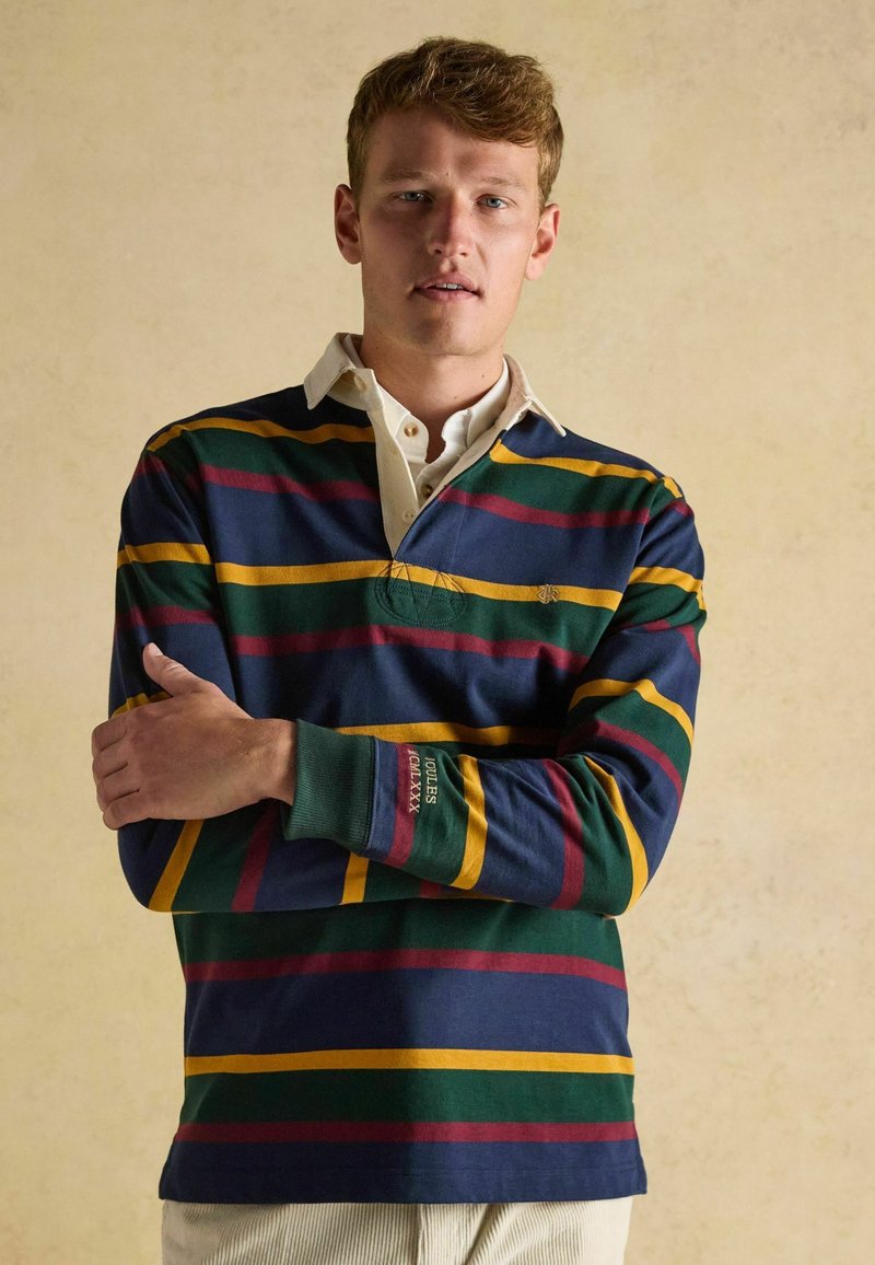 Langarm gestreiftes Poloshirt in Marineblau, Grün, Burgunderrot und Gelb. Mit einem weißen Kragen und gesticktem Logo auf der Brust und dem Ärmel.