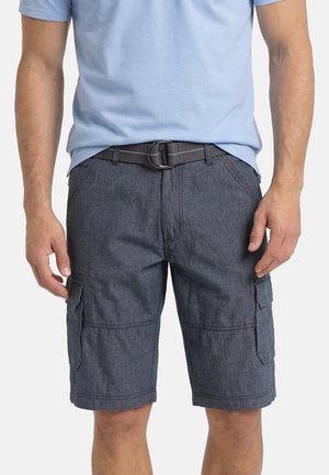 Mann trägt dunkelgraue Cargoshorts mit Seitentaschen und einem schwarzen Gürtel, kombiniert mit einem hellblauen Kurzarmhemd.