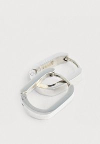 Ασημένια μεταλλικά σκουλαρίκια τύπου κρίκου με κομψό, ορθογώνιο σχέδιο. Διαθέτουν λείο φινίρισμα και κλείσιμο με μεντεσέ για εύκολη εφαρμογή.