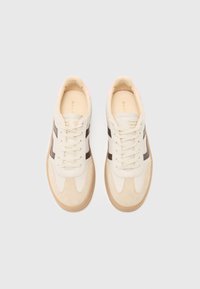 Sneaker in suede beige e pelle liscia con strisce marroni, punta rotonda e lacci crema. Accenti rosa sul tallone, suola in gomma naturale.