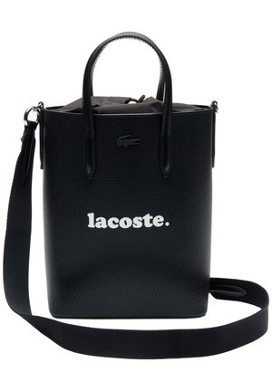 Schwarze, strukturierte Lacoste Tragetasche mit zwei Griffen, abnehmbarem Schulterriemen und Kordelzugverschluss oben.